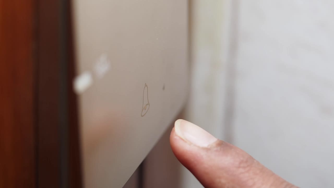 el dedo presionando un botón del timbre