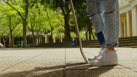 Young-woman-with-skateboard-standing-in-the-city-4k