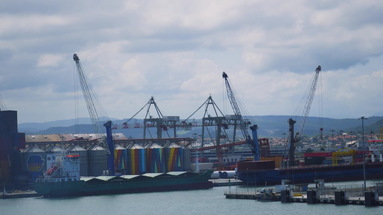 Cranes in Port with Cargo Ships Docked Ready to Transport Goods Worldwide.