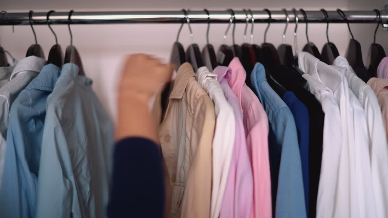 Woman going through different shirts in her wardrobe