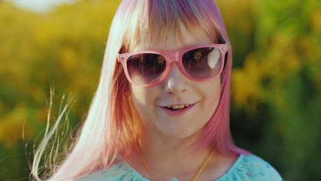 retrato de una chica con el pelo rosa con gafas de sol rosas