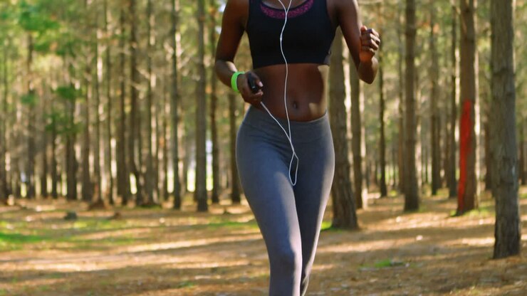 Donna che fa jogging nel bosco 4k