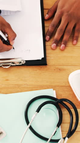 hands of doctor writing on a clipboard