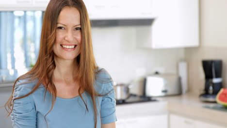 Mujer-Sonriente-Preparando-Verduras-En-La-Tabla-De-Cortar.