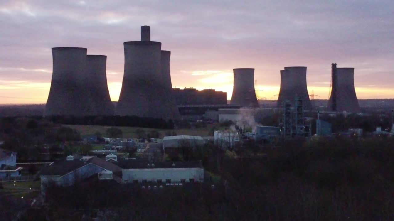 fiddlers ferry central eléctrica alimentada con carbón en desuso al amanecer, vista aérea que se eleva hacia un hito industrial