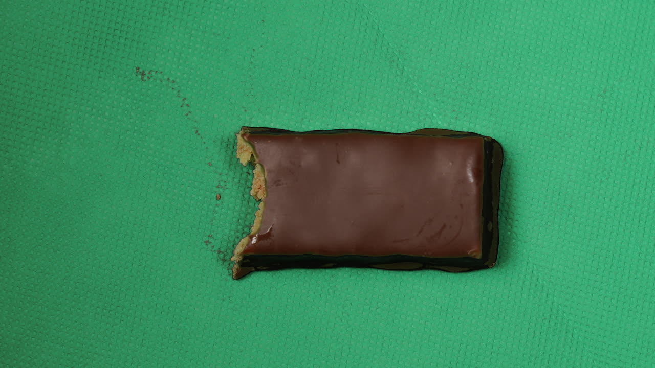 detener el movimiento de comer barra de chocolate bocado a bocado, fondo verde