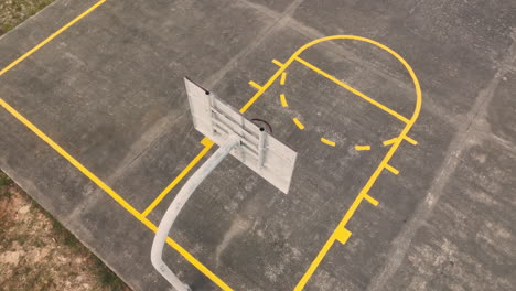 aerial top down shot of empty basketball court with basketball hoop during sunny day