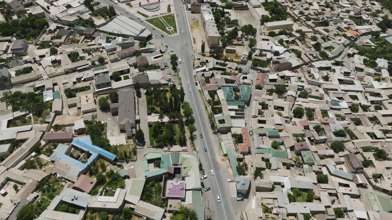 vista aérea de la ciudad de istaravshan con una carretera de asfalto entre estructuras densas en la provincia de sughd, tayikistán