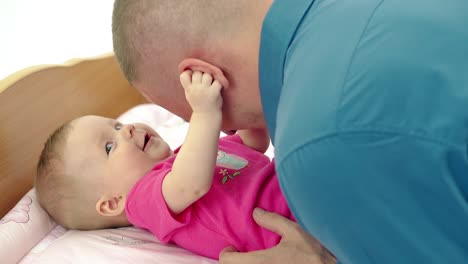 CU-Young-father-plays-with-daughter-who-lies-on-a-changing-table