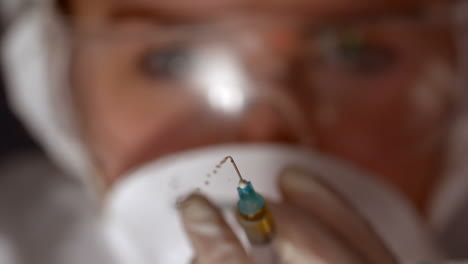 Scientist-spraying-syringe-of-chemical-to-camera