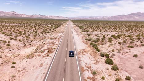 Drohne-Verfolgt-Ein-Auto,-Das-Auf-Einer-Geraden-Wüstenstraße-In-4K-Fährt