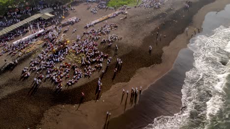 aerial pan over coastal balinese purification ritual in indonesia