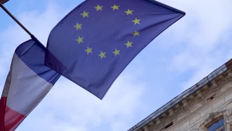 waving flag of france and europinian union in front ofe the blue sky