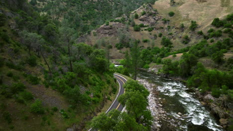 a car is driving on the road passing by a river near yosemite national park in california, usa