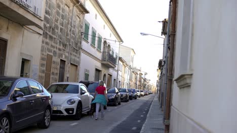 woman walking her dog in a narrow spanish town street