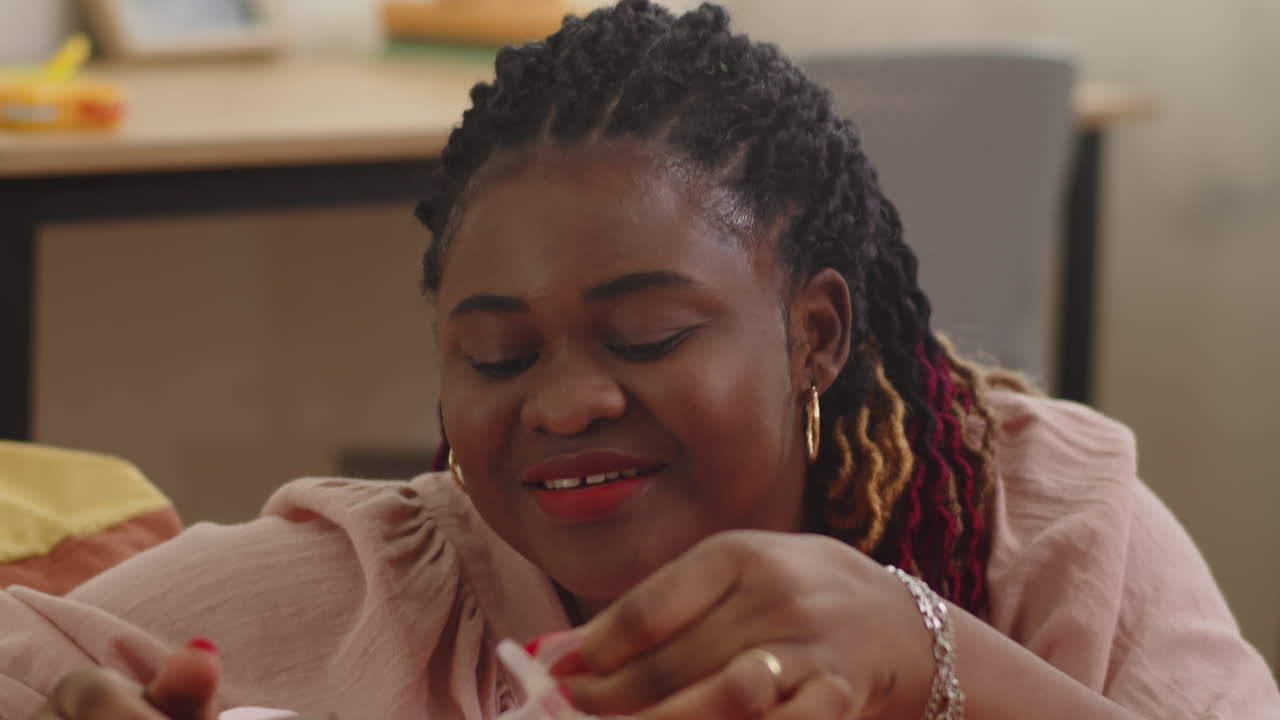 Black Mother Giving Pacifier to Infant Daughter
