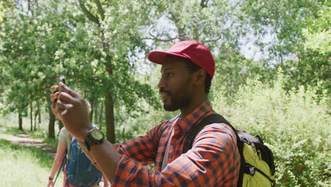 happy diverse couple with backpacks taking photos in park, slow motion