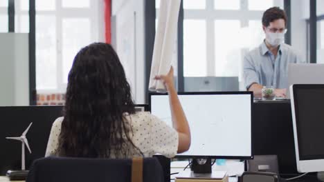 mujer pasando un documento a su colega en la oficina