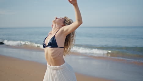 un artista contemporáneo practicando una coreografía sensual en una playa soleada de cerca.