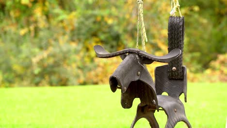 creative designer tire swing swaying empty, bull or bronco, no people, empty playground