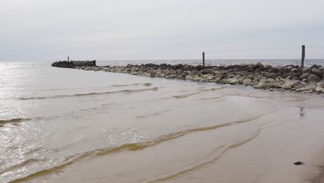 Breakwater-made-of-stone-in-calm-Baltic-sea-on-moody-day