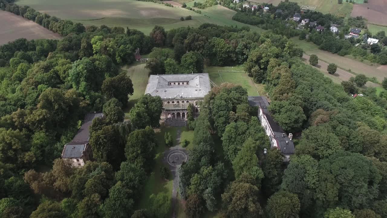 중부 유럽의 버려진 궁전, 초록색 나무와 부속 건물로 둘러싸인 큰 공원, 4k 드론 촬영