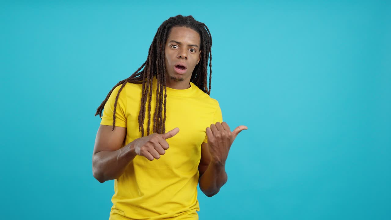Surprised man with dreadlocks pointing