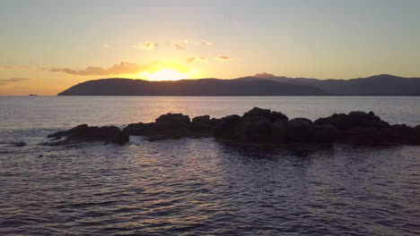 Aerial-Drone-Shot-of-a-Small-Rocky-Island-in-The-Mediterranean-Ocean-at-Sunset