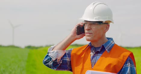 engineer talking on mobile phone while walking in farm 3