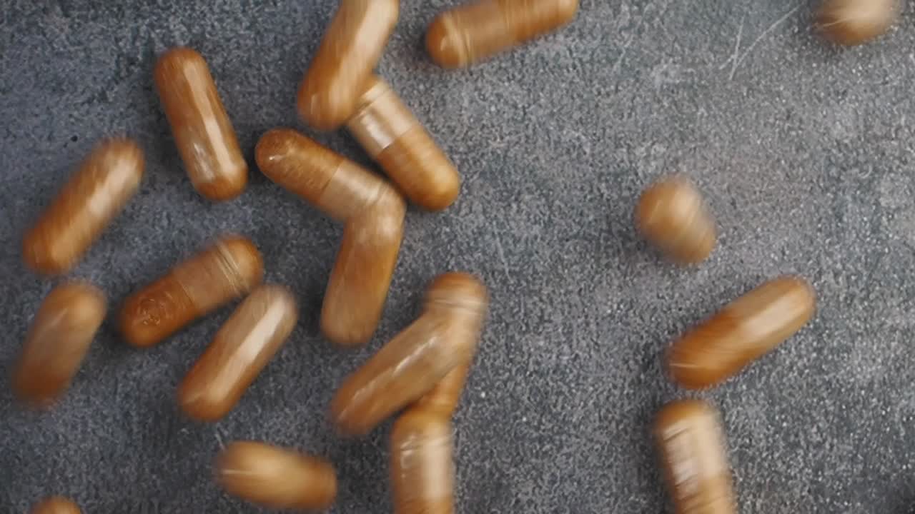 cápsulas marrones en una superficie gris