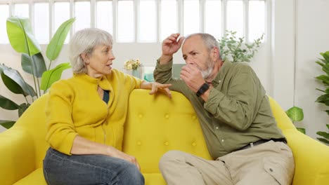 elderly couple having a disagreement on the couch