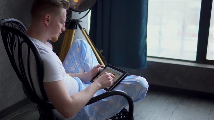 Man using tablet in a rocking chair