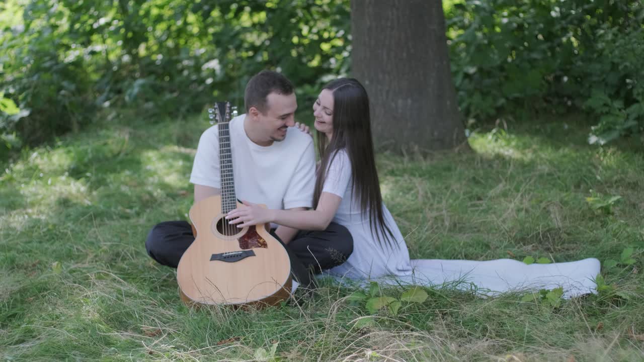 Romantic couple with guitar in the park