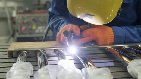 man wearing mask welding in a workshop. metal workers use manual labor. skilled welder. welder is welding the stainless steel pipes in the factory. welder industrial part in factory.