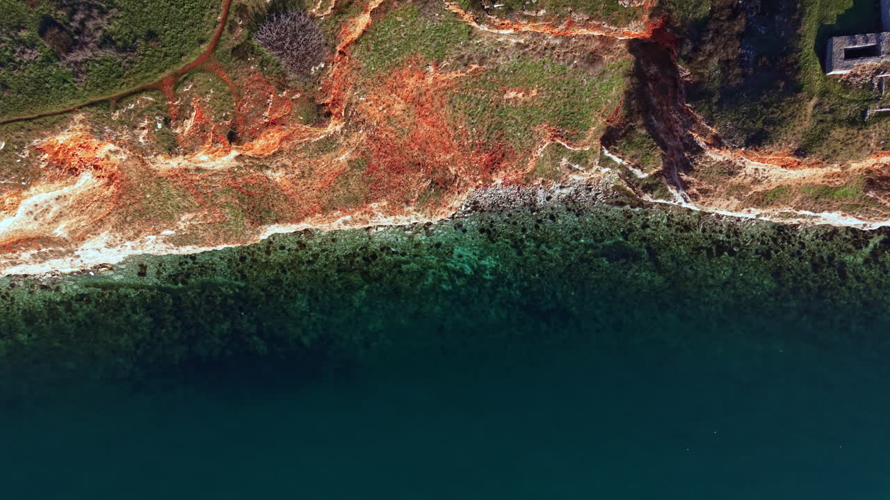 View of a coastal area with cliffs, water, and land during daylight hours near a shoreline in a natural setting