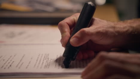 close up - agent or government official erasing and hiding sensitive information. person using black marker to censor important official text on document or report. conspiracy or evidence cover up