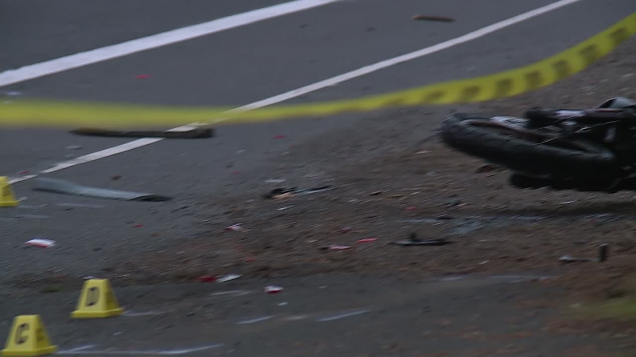 PANNING SHOT OF SKID MARKS TO MOTORCYCLE CRASH BEHIND POLICE TAPE