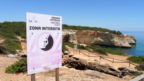 restricted area sign at benagil cliff on sunny day