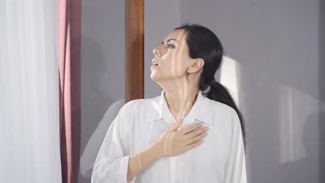 una mujer luchando por respirar, respirando aire fresco en su casa.