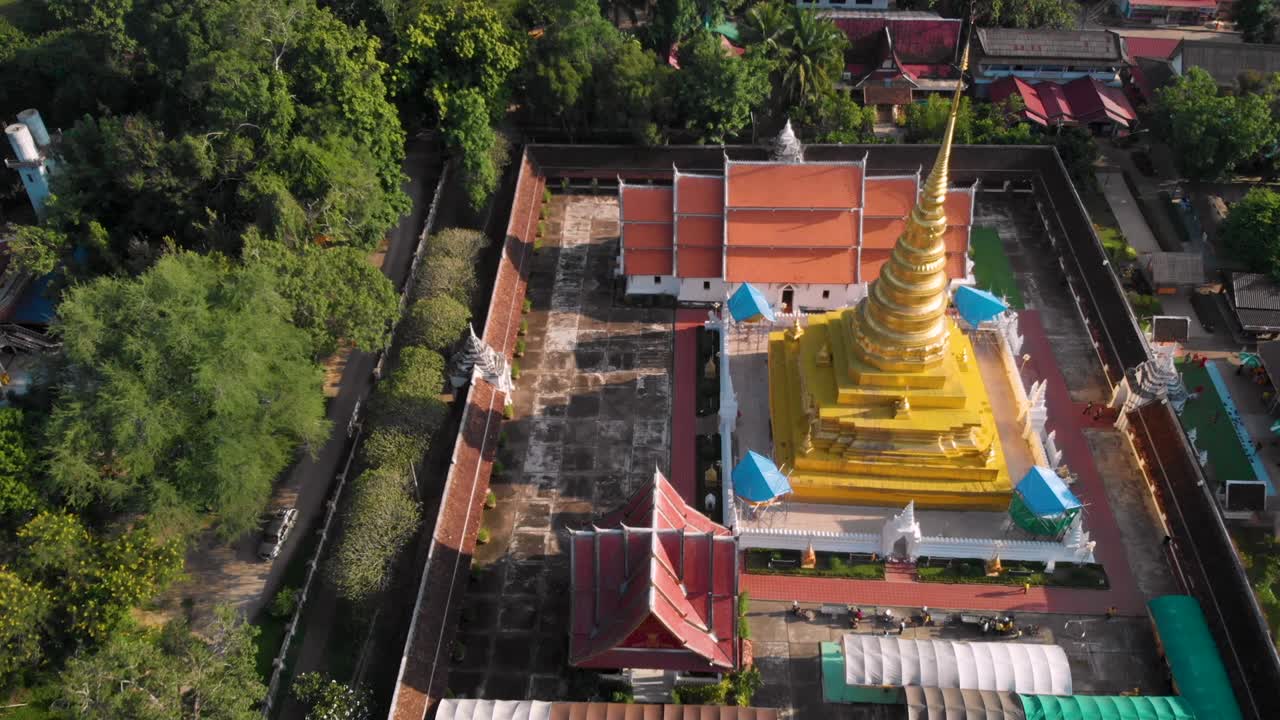 4k tailandés templo dorado drone disparado volando hacia arriba y por encima, provincia de naan, cultura tradicional tailandesa, budismo tailandés wat, destino de viaje de asia, tranquilo tranquilo pintoresco, en órbita, no urbano, cámara inclinada hacia abajo