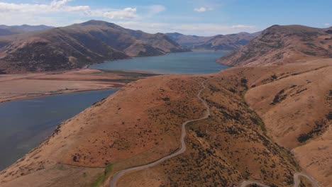 Beautiful-scenery-view-of-grassy-hillside-and-distant-lake-in-the-middle-of-romantic-valley-on-warm-sunny-day-in-4k