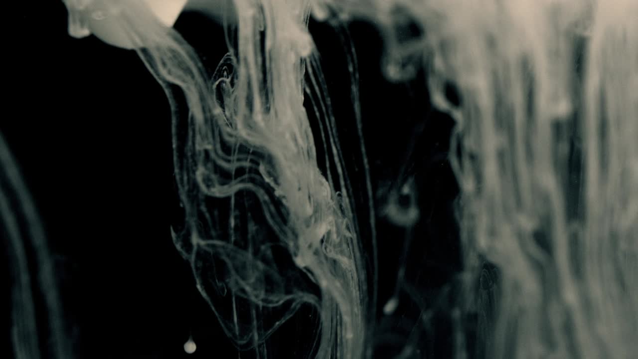 White Ink Effect In Water Filmed On Black Background