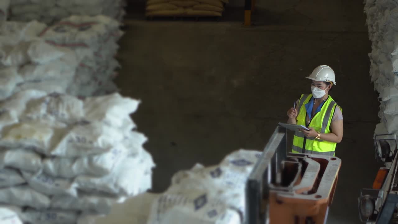 una trabajadora de almacén está contando productos y comprobando las existencias de la industria química.