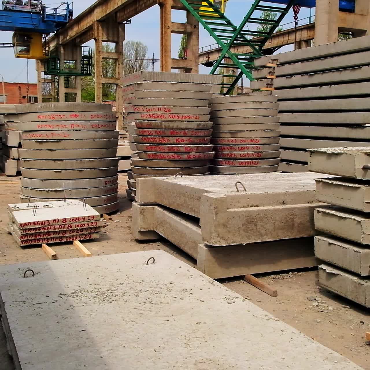 Cement grey building materials with red letters and numbers. Construction metal supports and mechanisms at the backdrop
