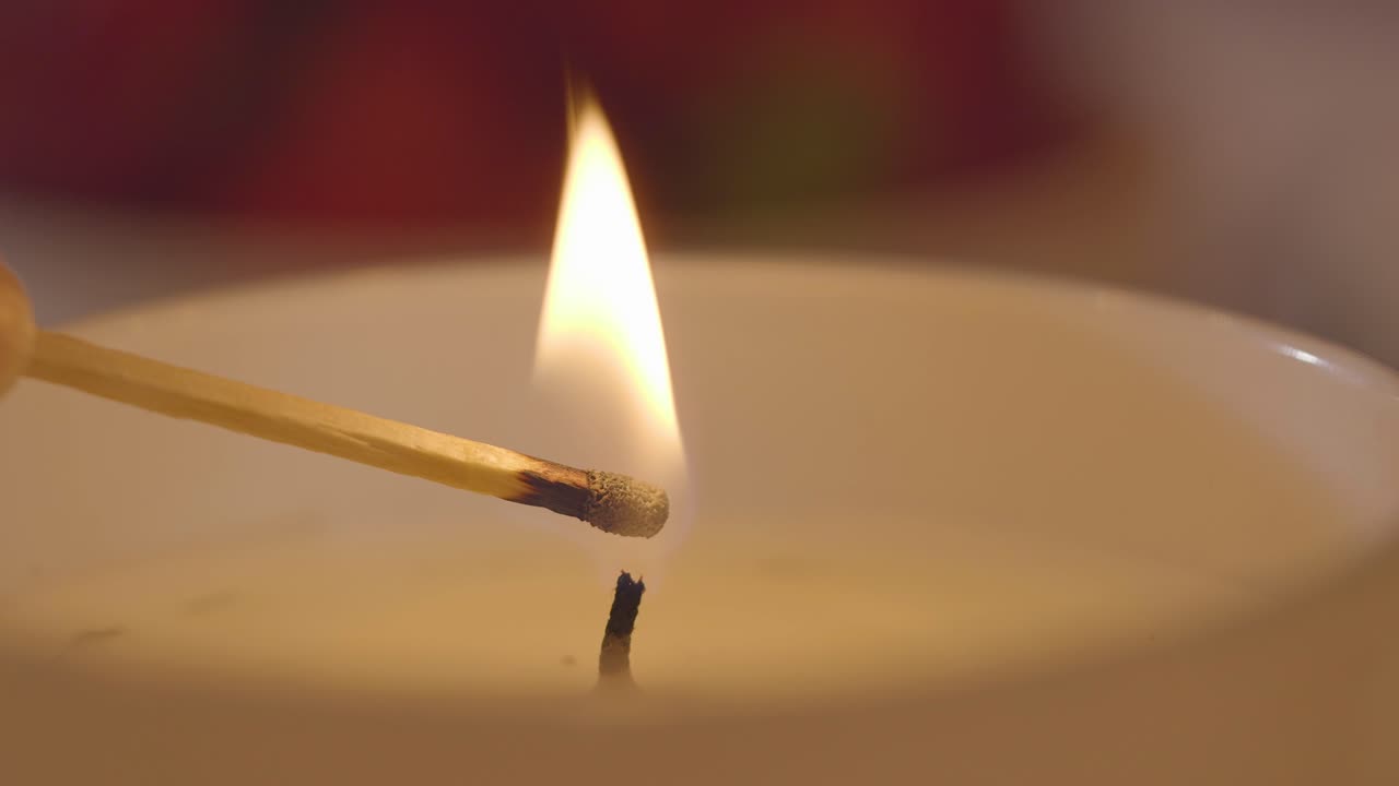 un primer plano de un fósforo encendiendo una vela
