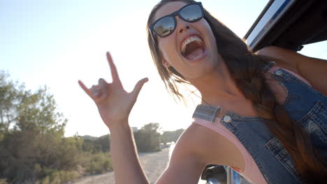 Mujer-Joven-Colgando-De-La-Ventanilla-De-Un-Coche-Durante-Un-Viaje-Por-Carretera.