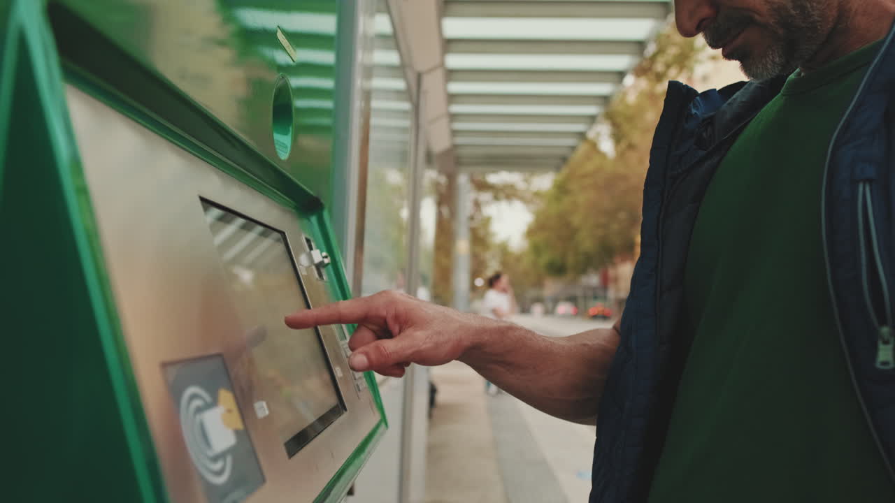 Man Using Ticket Machine at Bus Stop