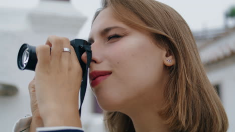 closeup tourist taking photos with old fashioned camera. blonde girl checking