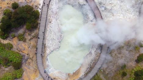peligroso humo de azufre se eleva desde el cráter de sikidang en indonesia, vista aérea de arriba hacia abajo