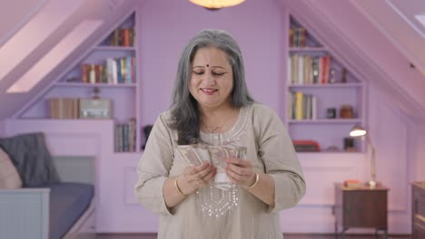 una anciana india feliz contando dinero.